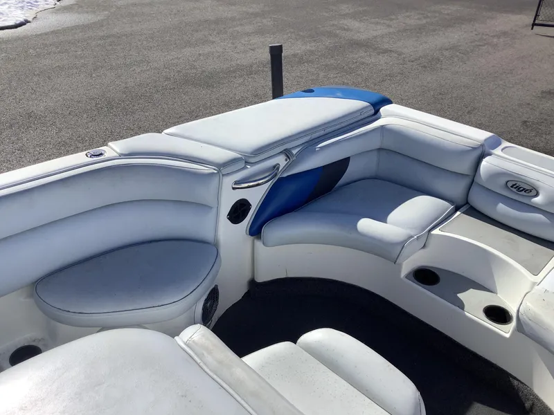 Slide: The Image of 2002 Tigé 22i boat interior with white and blue seating, cup holders, and logo. - 37