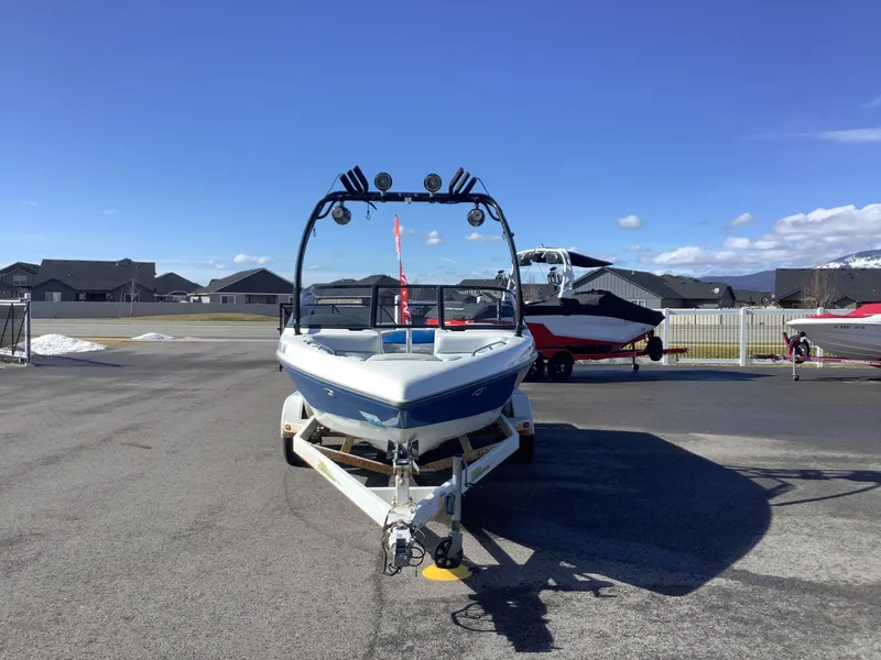 Slide: The Image of 2002 Tigé 22i boat on trailer, parked outdoors under clear blue sky. - 4