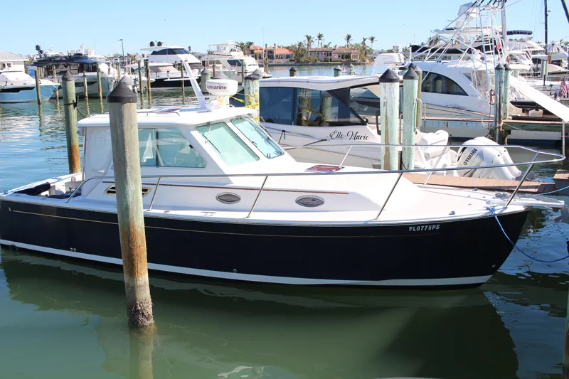 The Image of 2007 Back Cove 29 boat docked in a marina, surrounded by other vessels. - 0