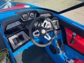Slide: The Image of 2023 MasterCraft NXT22 boat dashboard with steering wheel and control panel. - 6