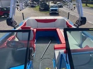 Slide: The Image of 2023 MasterCraft NXT22 boat interior with red and white seating, open bow design. - 8