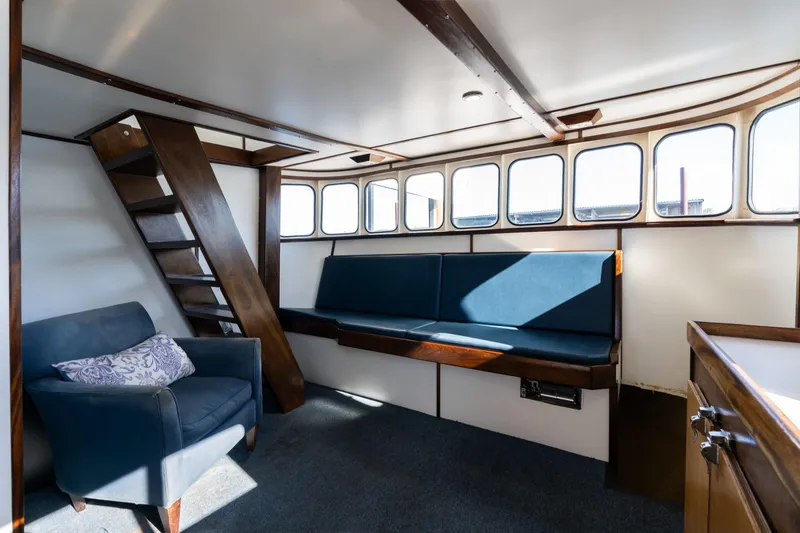 Slide: The Image of Interior of a 1980 commercial troller with seating, stairs, and windows. - 14