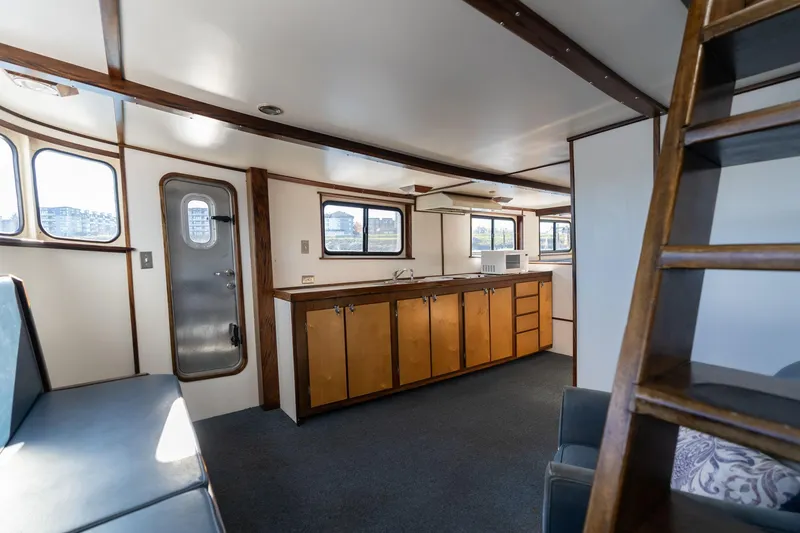 Slide: The Image of Interior of a 1980 Commercial Troller boat with wooden cabinets and seating. - 16