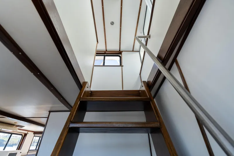 Slide: The Image of Interior view of a 1980 commercial Troller boat with wooden stairs and metal railing. - 17