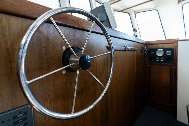 Slide: The Image of 1980 Commercial Troller boat interior with wooden paneling and steering wheel. - 24