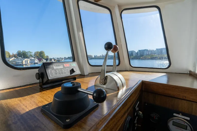 Slide: The Image of Interior of a 1980 Commercial Troller boat with control levers and scenic water view. - 26