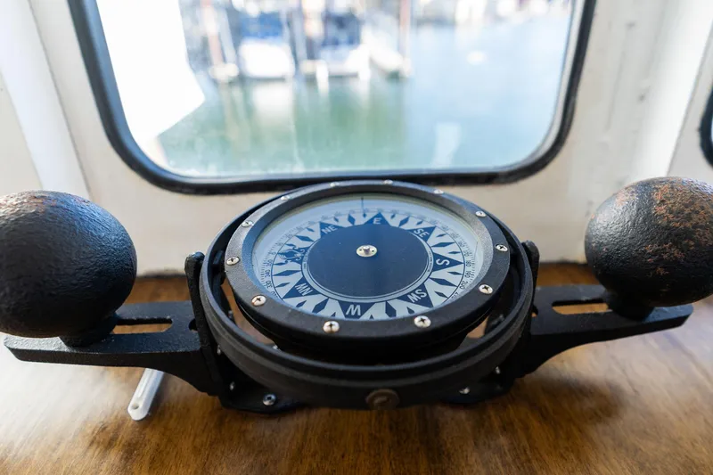 Slide: The Image of Vintage 1980 Troller commercial boat compass on wooden dashboard, near window with water view. - 27