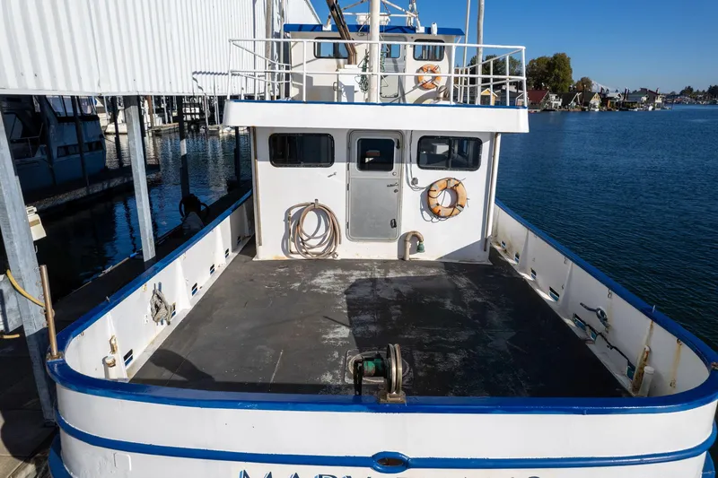 Slide: The Image of 1980 Commercial Troller boat docked, spacious deck, calm water, clear sky. - 3