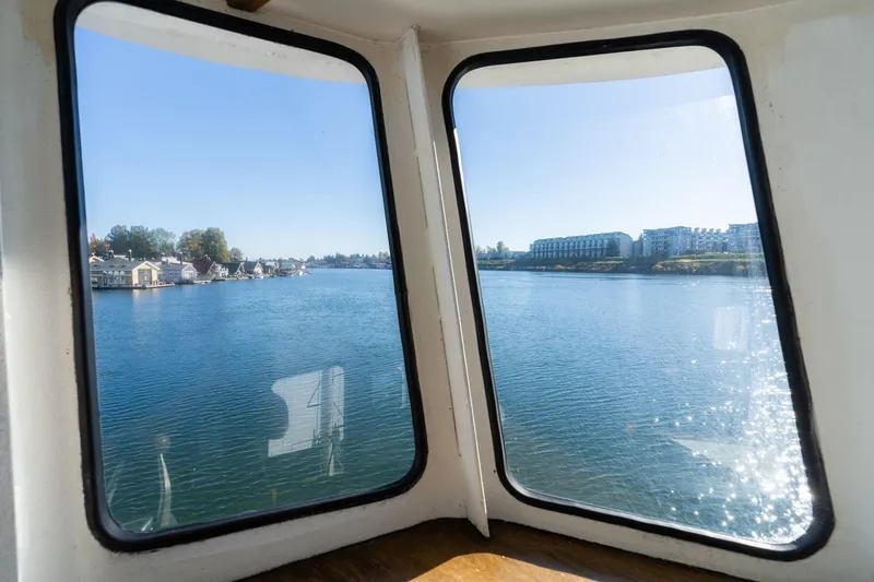 Slide: The Image of View from 1980 Commercial Troller boat window overlooking calm water and distant buildings. - 30