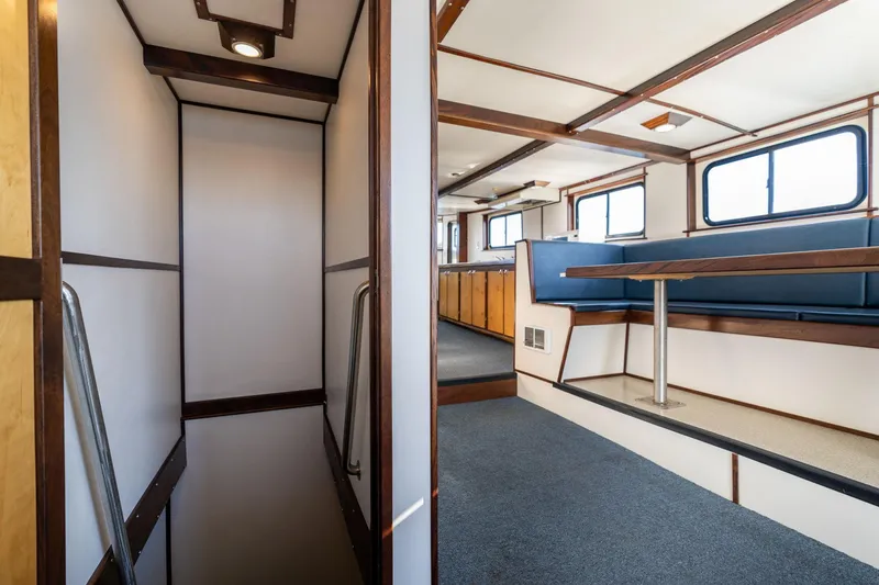 Slide: The Image of 1980 Commercial Troller interior with seating area and stairs, featuring wood accents and large windows. - 45