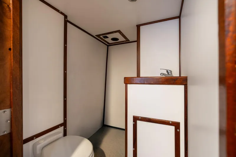 Slide: The Image of 1980 Commercial Troller bathroom interior with white walls and wooden trim. - 48
