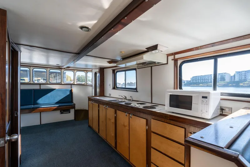 Slide: The Image of 1980 Commercial Troller interior with kitchen, microwave, and seating area. - 8