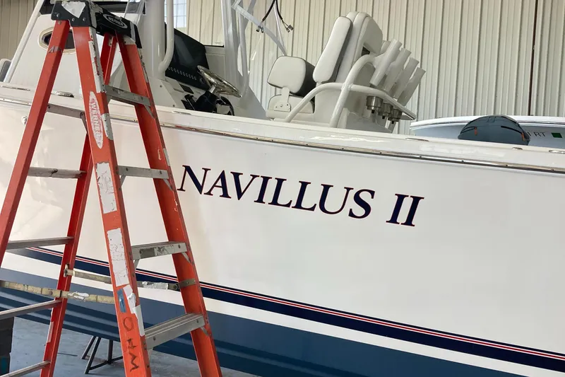 Slide: The Image of 2024 Regulator 28 Forward Seating boat named Navillus II in a garage with a ladder. - 3