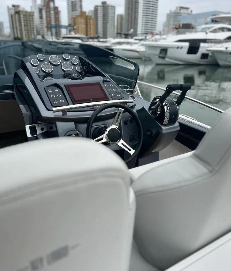 Slide: The Image of 2024 Sessa Marine Key Largo 27 Outboard Line dashboard with city marina backdrop. - 12