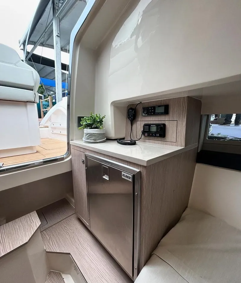 Slide: The Image of 2024 Sessa Marine Key Largo 27 cabin interior with modern kitchenette and control panel. - 14