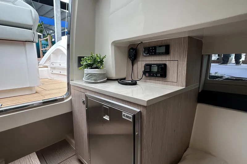 Slide: The Image of Interior of 2024 Sessa Marine Key Largo 27, featuring a compact kitchenette with modern appliances. - 15
