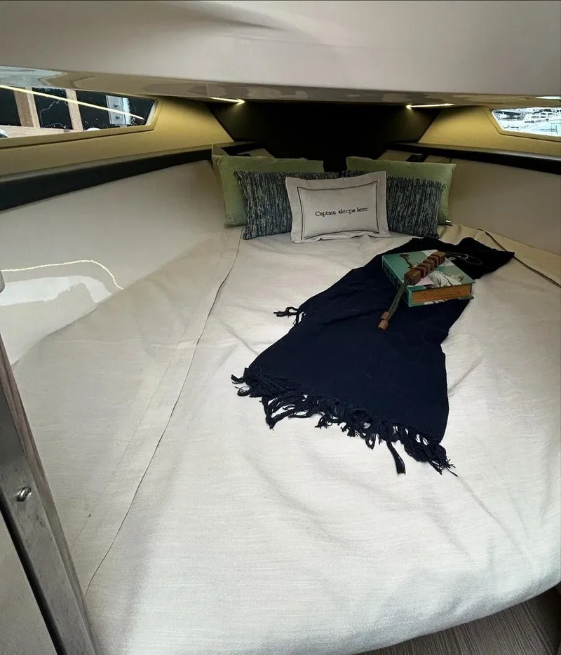 Slide: The Image of 2024 Sessa Marine Key Largo 27 cabin interior with cozy bedding and decorative pillows. - 17