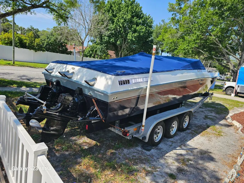 Slide: The Image of 1983 Chris-Craft 312 SL boat on trailer, covered, parked outdoors. - 6
