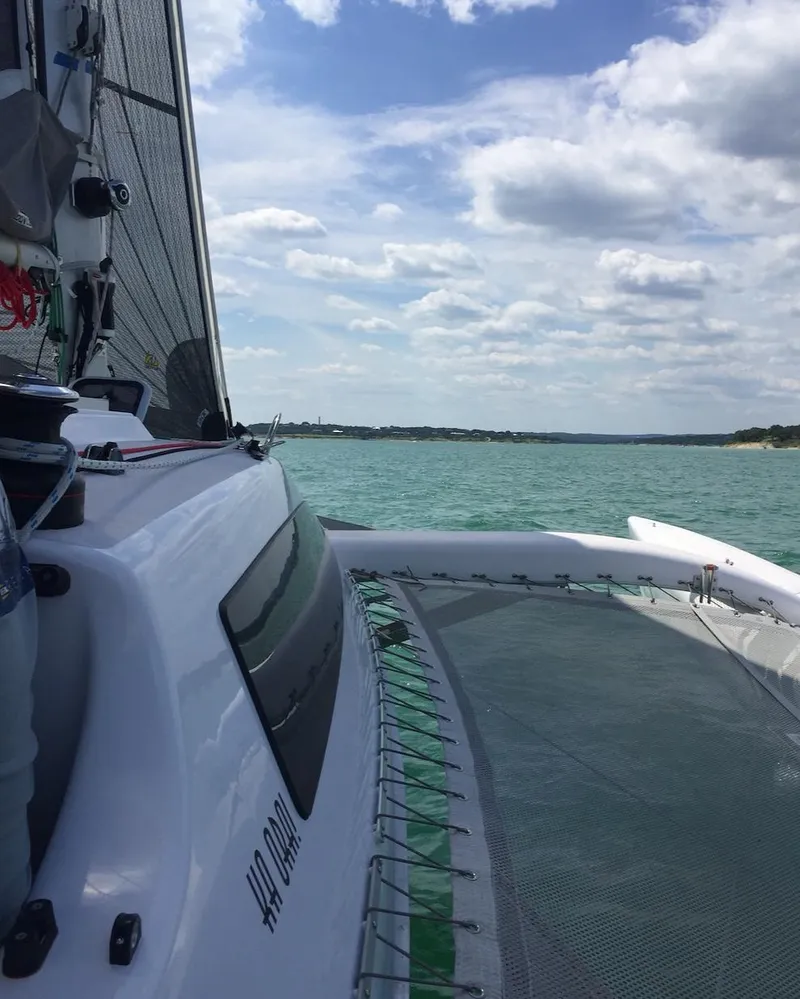 Slide: The Image of Sailing on a 2025 Corsair 970 Sport trimaran under a partly cloudy sky. - 10