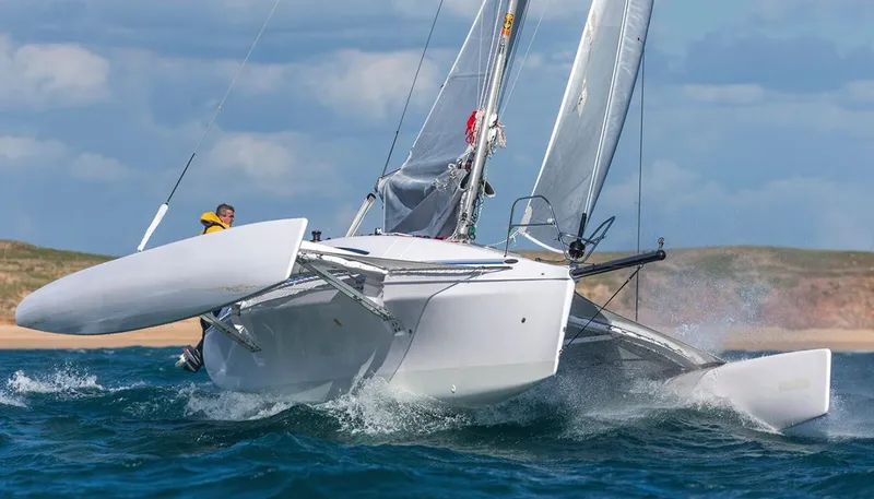 The Image of 2025 Corsair 970 Sport trimaran sailing swiftly on open water. - 1