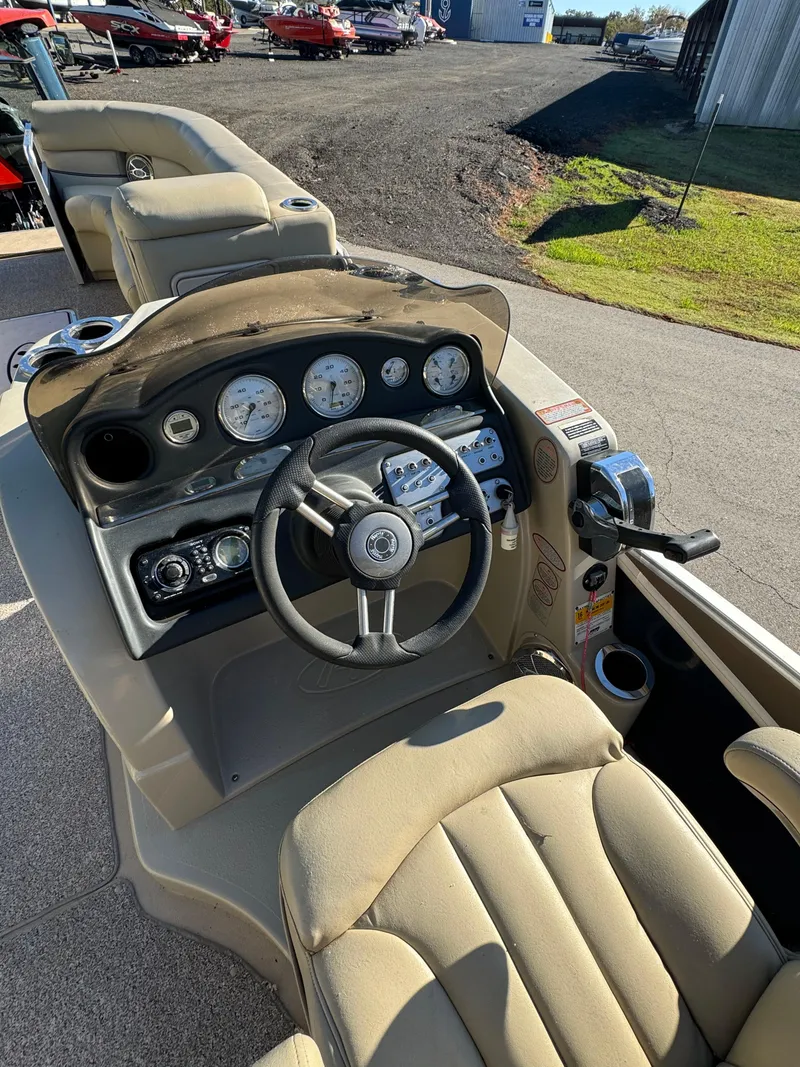 Slide: The Image of 2011 Harris 250GMSE boat dashboard with steering wheel and gauges in a sunny outdoor setting. - 9