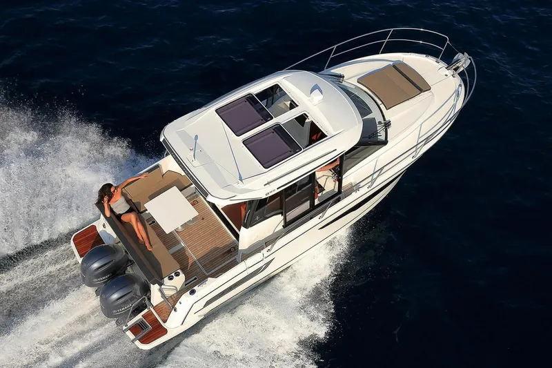 Slide: The Image of 2019 Jeanneau NC 895 cruising on open water, featuring dual outboard engines. - 17