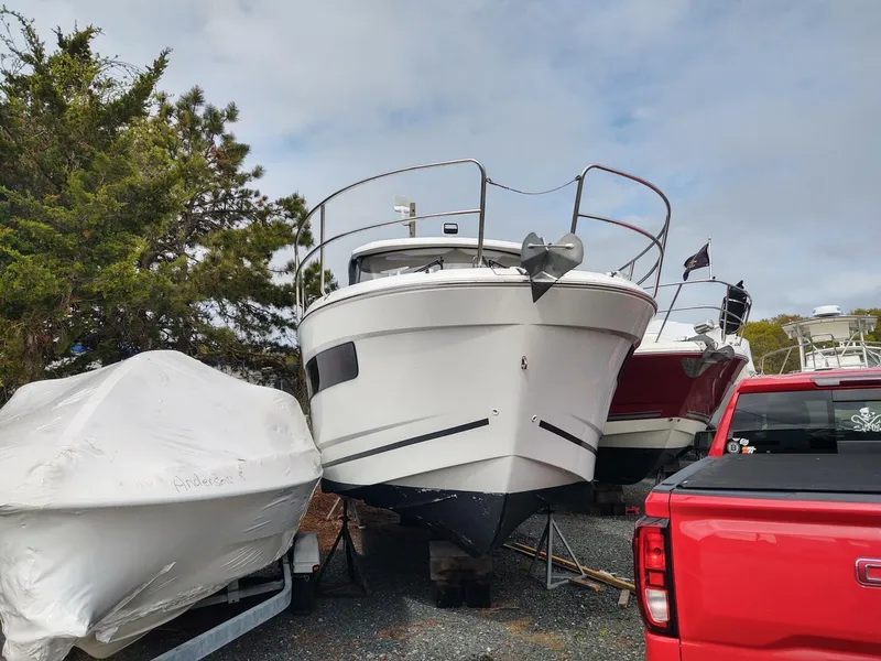 Slide: The Image of 2019 Jeanneau NC 895 boat on trailer, parked outdoors near trees and vehicles. - 4
