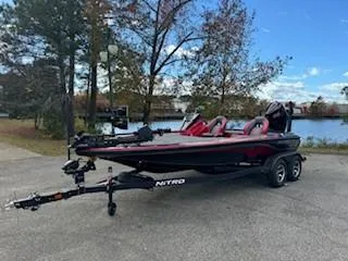 The Image of 2025 Nitro Z19 boat on trailer by a lake, surrounded by trees. - 0