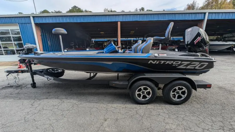 The Image of 2025 Nitro Z20 XL Pro fishing boat on trailer, parked outside a blue building. - 0