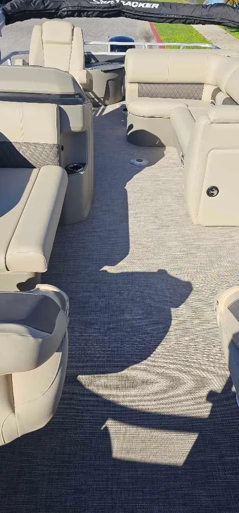 Slide: The Image of 2025 Sun Tracker Fishin' Barge 20 DLX interior with beige seating and spacious layout. - 3