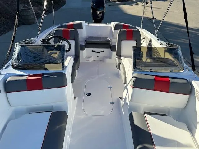 Slide: The Image of 2025 Tahoe T21 boat interior with red and gray seating, dual windshields, and steering wheel. - 13