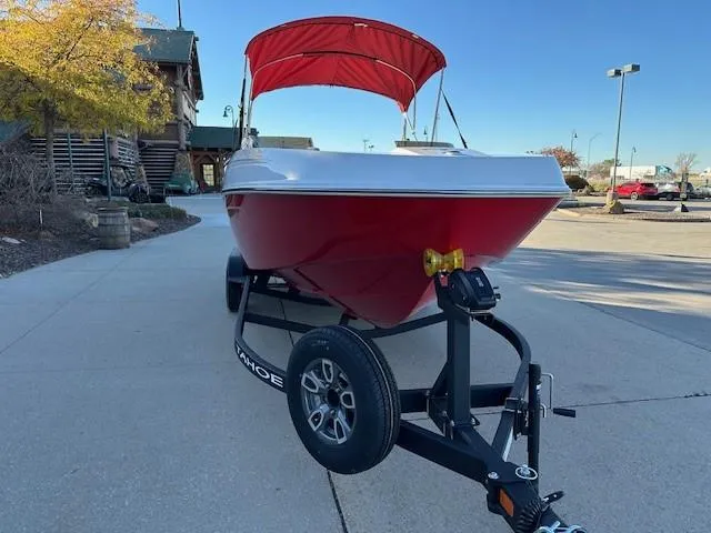 Slide: The Image of Red 2025 Tahoe T21 boat on trailer with canopy in parking lot. - 2