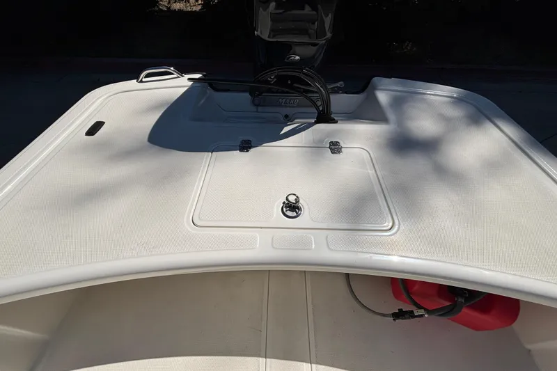 Slide: The Image of 2025 Mako Pro Skiff 17 CC boat deck with storage compartment and fuel tank. - 17