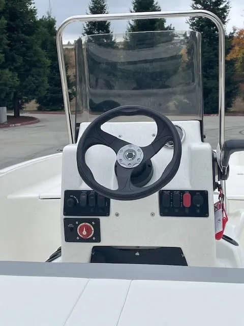 Slide: The Image of 2025 Mako Pro Skiff 17 CC boat console with steering wheel and controls. - 3