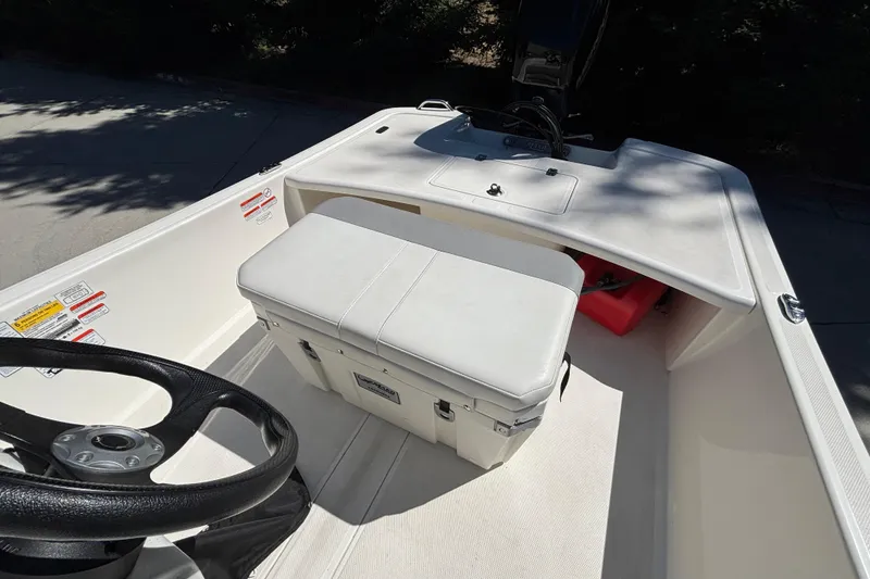 Slide: The Image of 2025 Mako Pro Skiff 17 CC interior with steering wheel and storage compartment. - 16