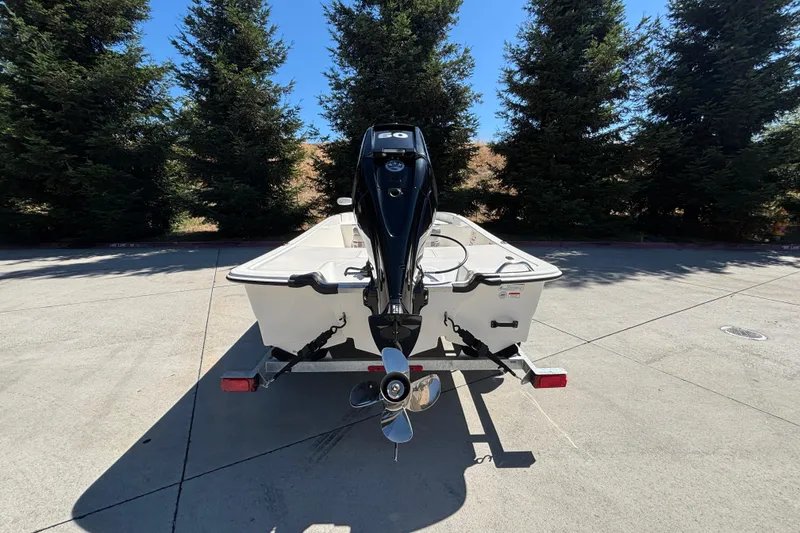 Slide: The Image of 2025 Mako Pro Skiff 17 CC boat on trailer, rear view with outboard motor. - 7