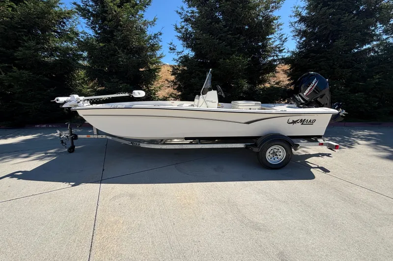 Slide: The Image of 2025 Mako Pro Skiff 17 CC boat on trailer, parked outdoors. - 1