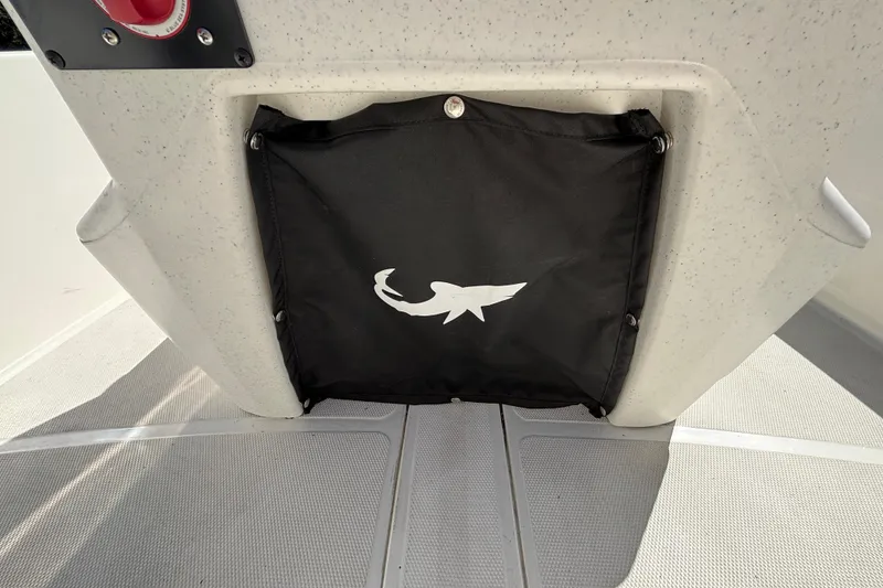 Slide: The Image of 2025 Mako Pro Skiff 17 CC storage compartment with shark logo on black cover. - 27