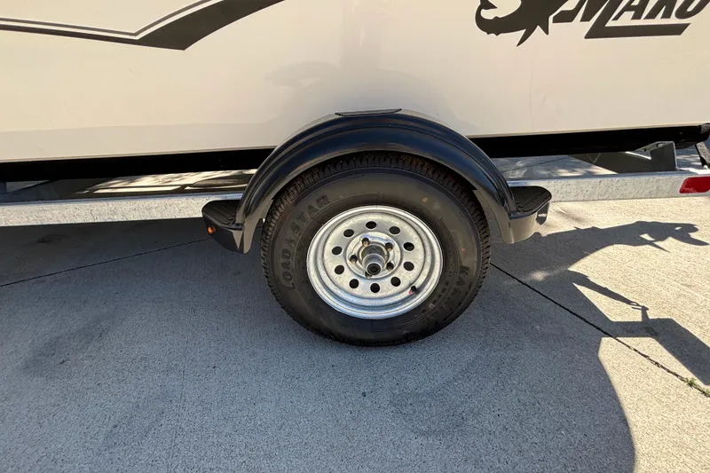 Slide: The Image of Trailer wheel of 2025 Mako Pro Skiff 17 CC boat on concrete surface. - 25