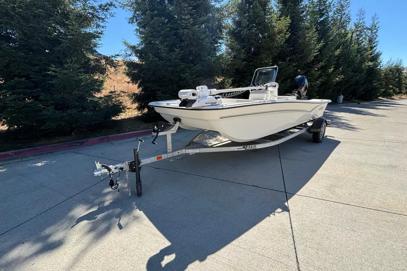 Slide: The Image of 2025 Mako Pro Skiff 17 CC boat on trailer, parked outdoors near trees. - 4