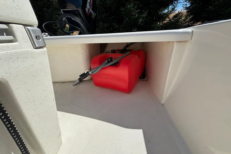 Slide: The Image of Storage compartment of 2025 Mako Pro Skiff 17 CC with red fuel tank. - 34