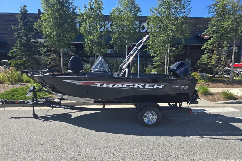 The Image of 2025 Tracker Pro Guide V-175 WT boat on trailer, parked outdoors near trees. - 0