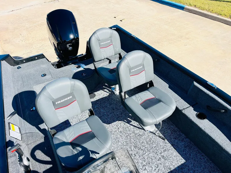 Slide: The Image of 2025 Tracker Pro Guide V-16 SC boat interior with four gray seats and motor. - 15