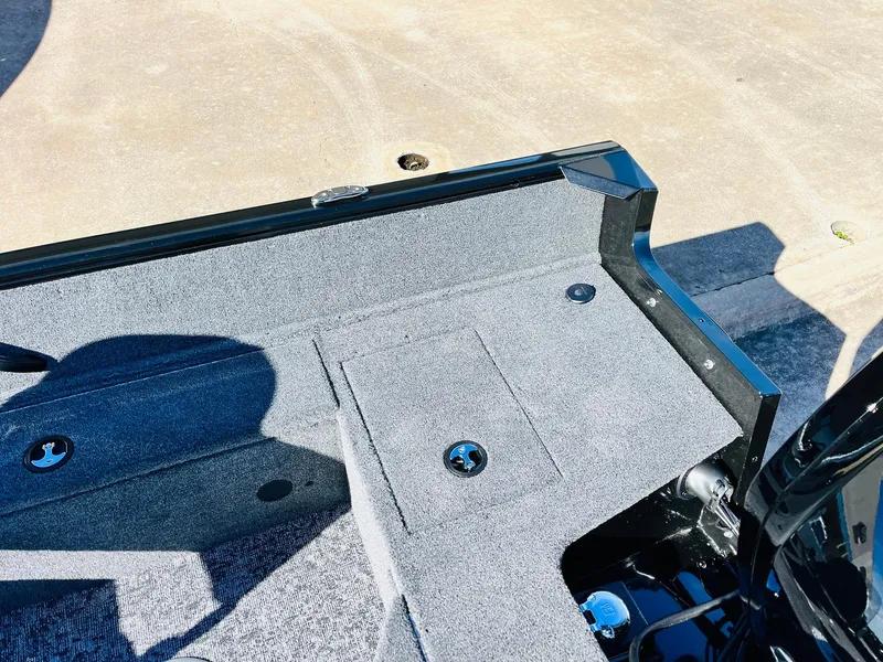 Slide: The Image of 2025 Tracker Pro Guide V-16 SC boat interior with carpeted deck and storage compartments. - 27