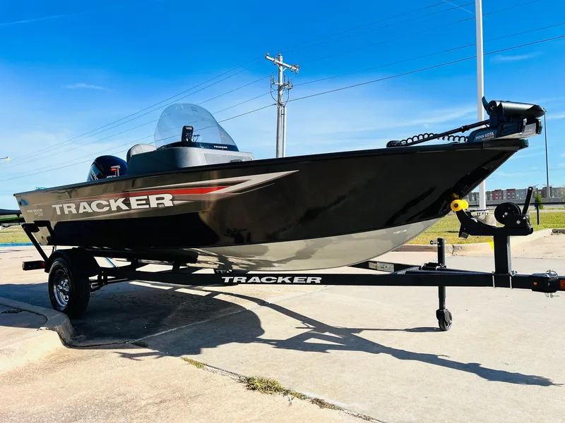 Slide: The Image of 2025 Tracker Pro Guide V-16 SC boat on trailer, sleek black design, sunny day. - 3