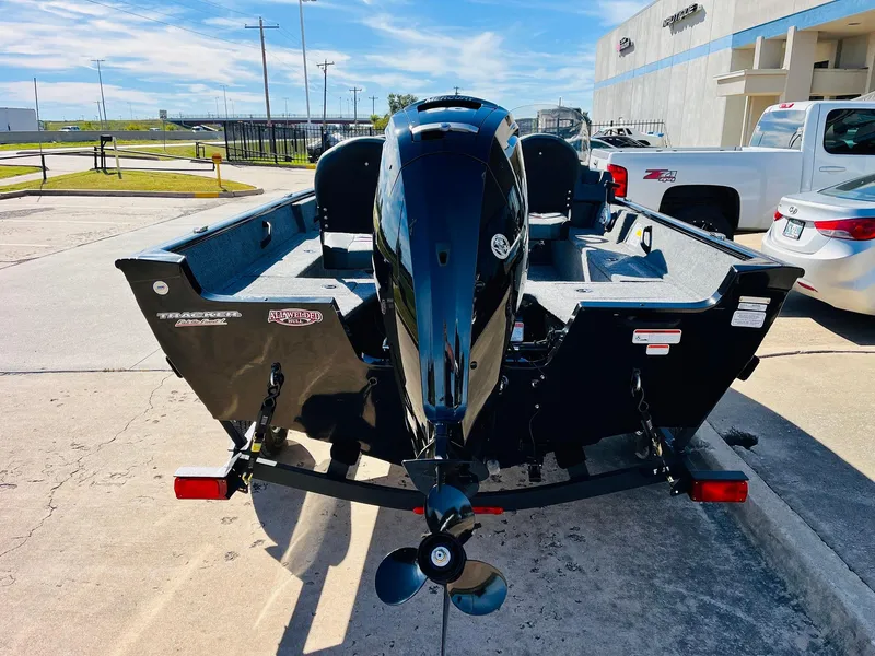 Slide: The Image of 2025 Tracker Pro Guide V-16 SC boat with motor, parked outdoors. - 5