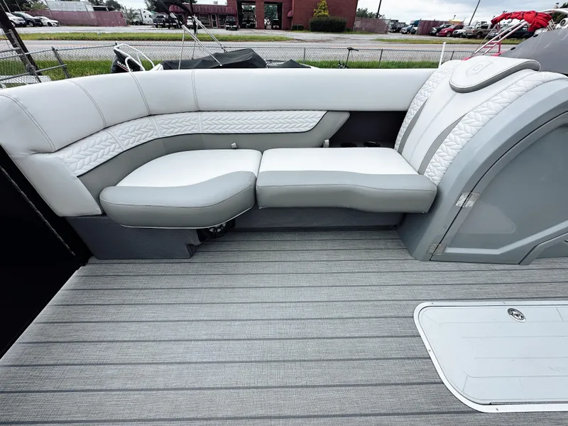Slide: The Image of 2025 Godfrey Monaco 23' Tritoon with dual flip lounge seating, gray upholstery, and deck flooring. - 14
