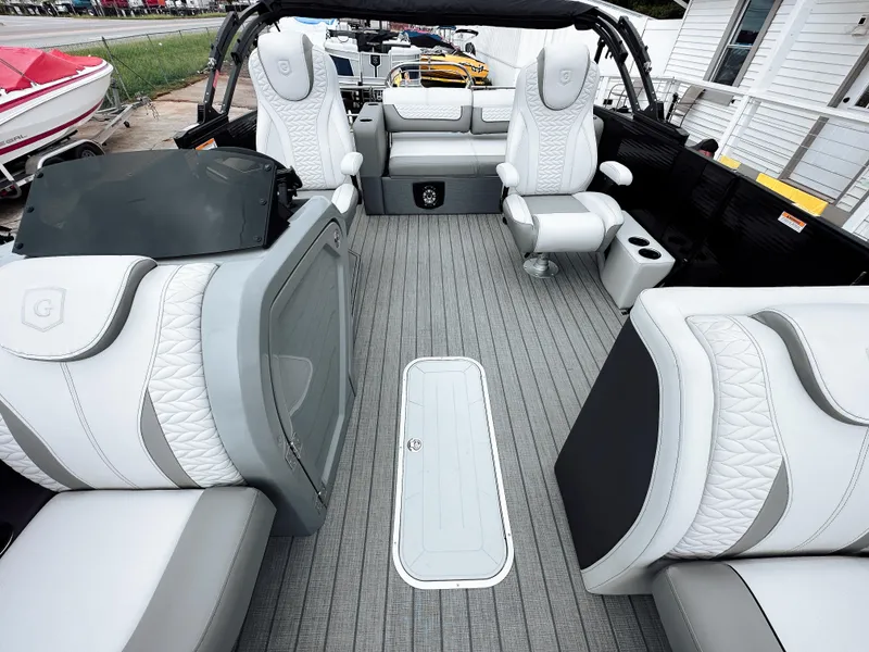 Slide: The Image of 2025 Godfrey Monaco 23' Tritoon interior with luxurious seating and modern design. - 3