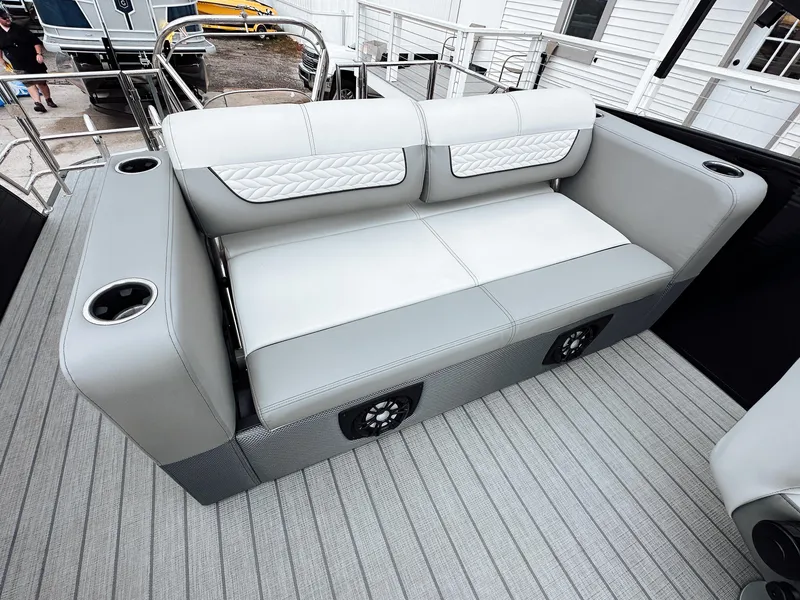 Slide: The Image of 2025 Godfrey Monaco 23' Tritoon with dual flip lounge seating, gray upholstery, and integrated speakers. - 4