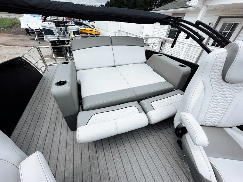 Slide: The Image of 2025 Godfrey Monaco 23' Tritoon with dual flip lounge seating, gray and white interior. - 7